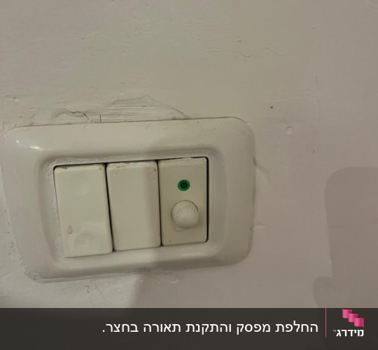 מתג חשמל עם כפתור דימר על קיר לבן